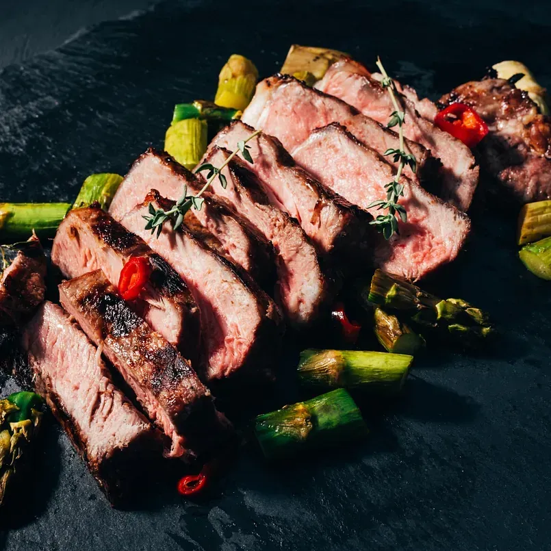 Un primer plano de un filete en un plato con verduras.