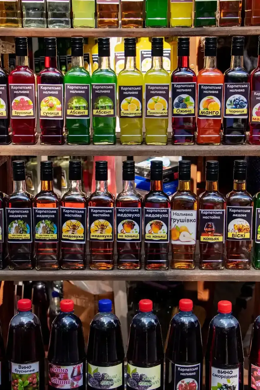 En una tienda, se pueden ver filas de coloridas botellas de vidrio de diversos licores y destilados.