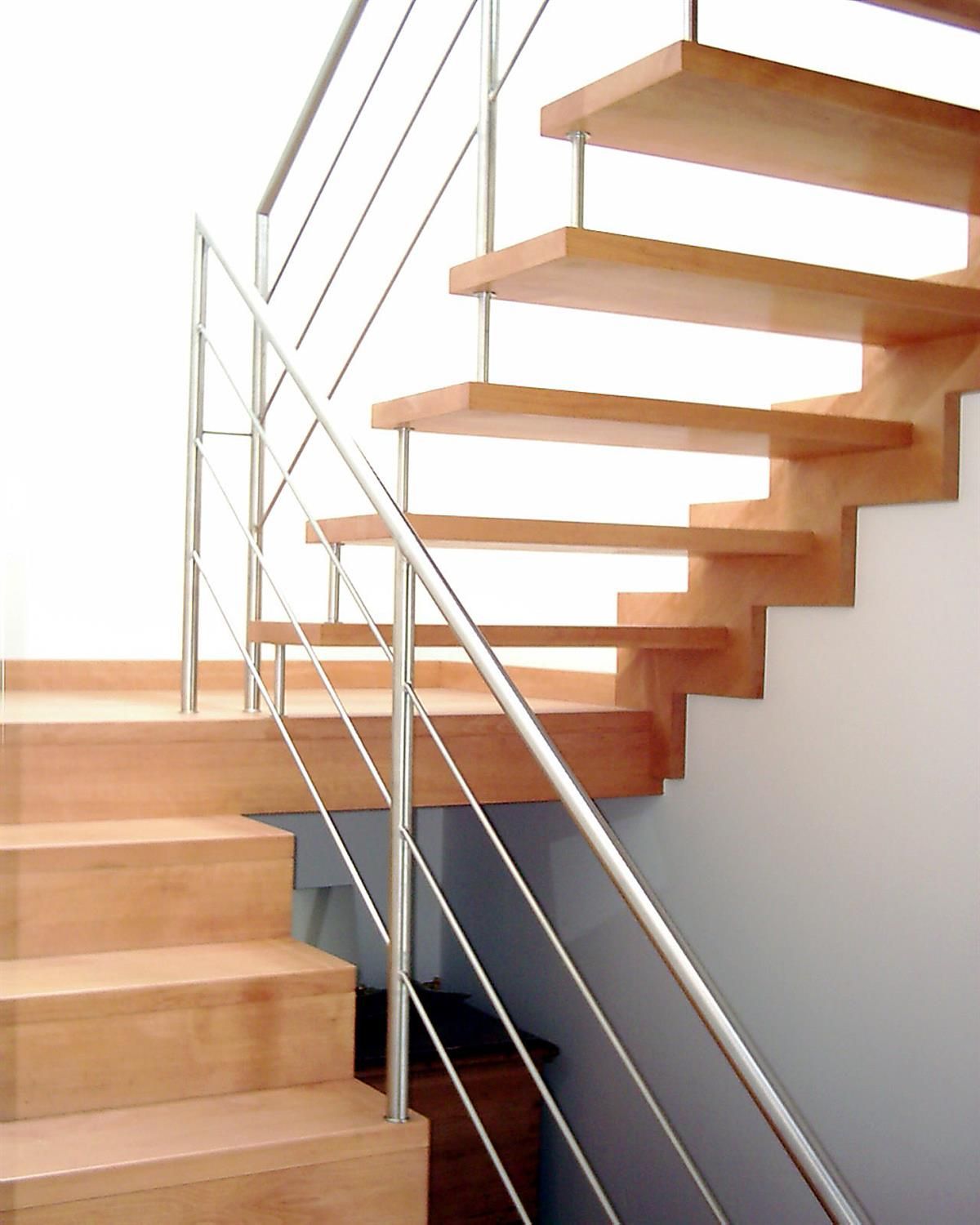 Eine Holztreppe mit Edelstahlgeländer