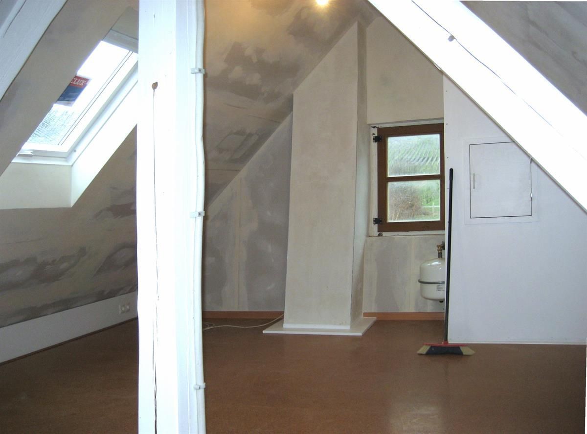 Ein leerer Raum mit einem Kamin und einem Fenster