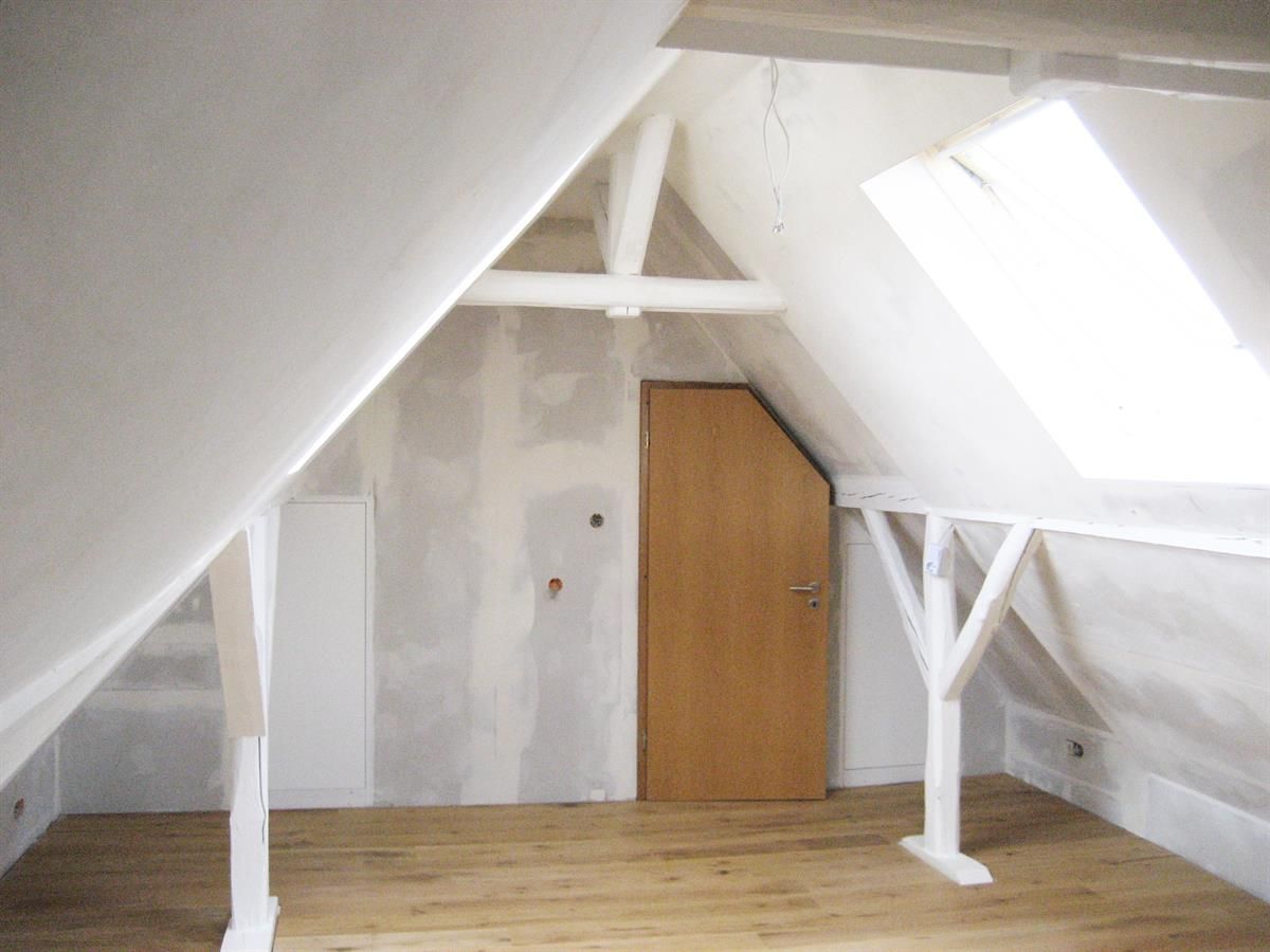 Ein leerer Dachboden mit einer Tür und einem Oberlicht