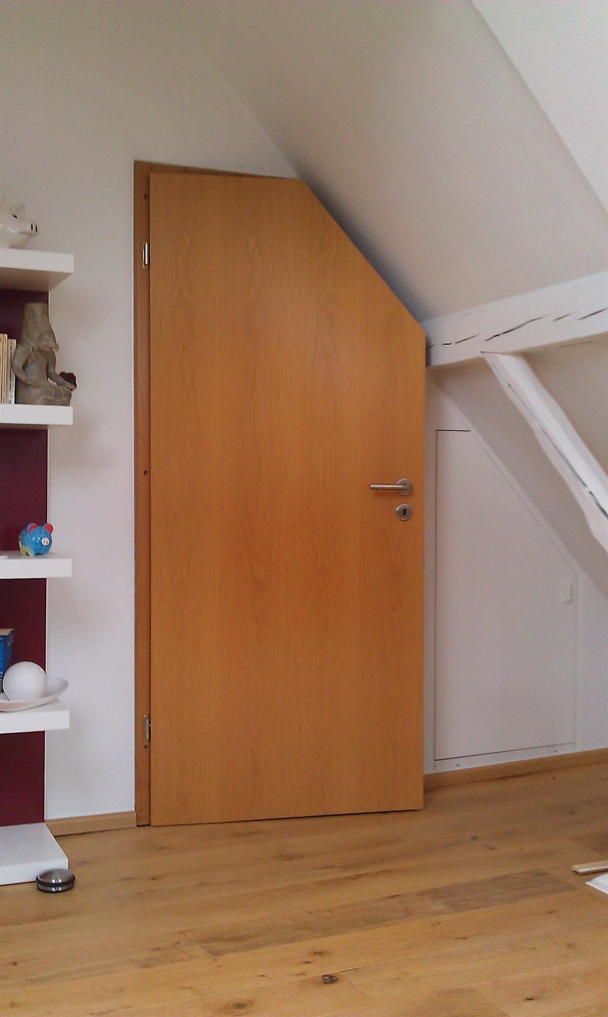 Eine Holztür in einem Raum mit Dachschräge