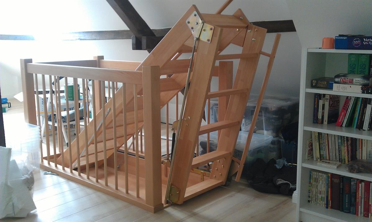 Eine Holztreppe in einem Raum mit Bücherregalen