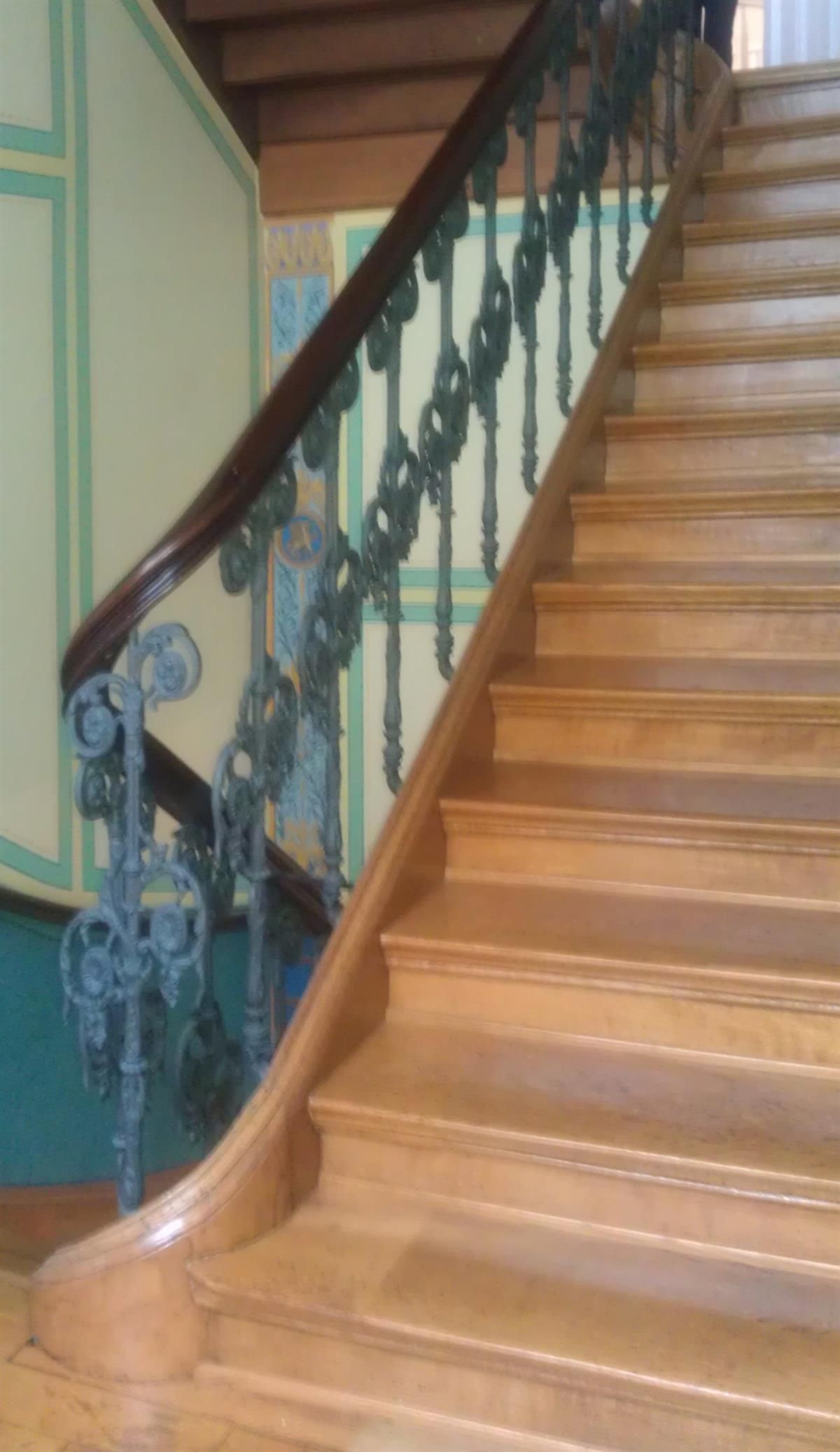 Eine Holztreppe mit schmiedeeisernem Geländer