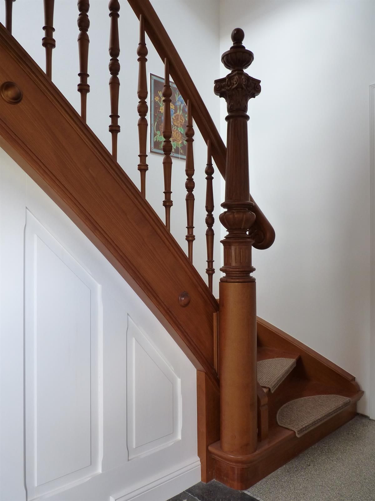 Eine Holztreppe mit einer weißen Wand dahinter