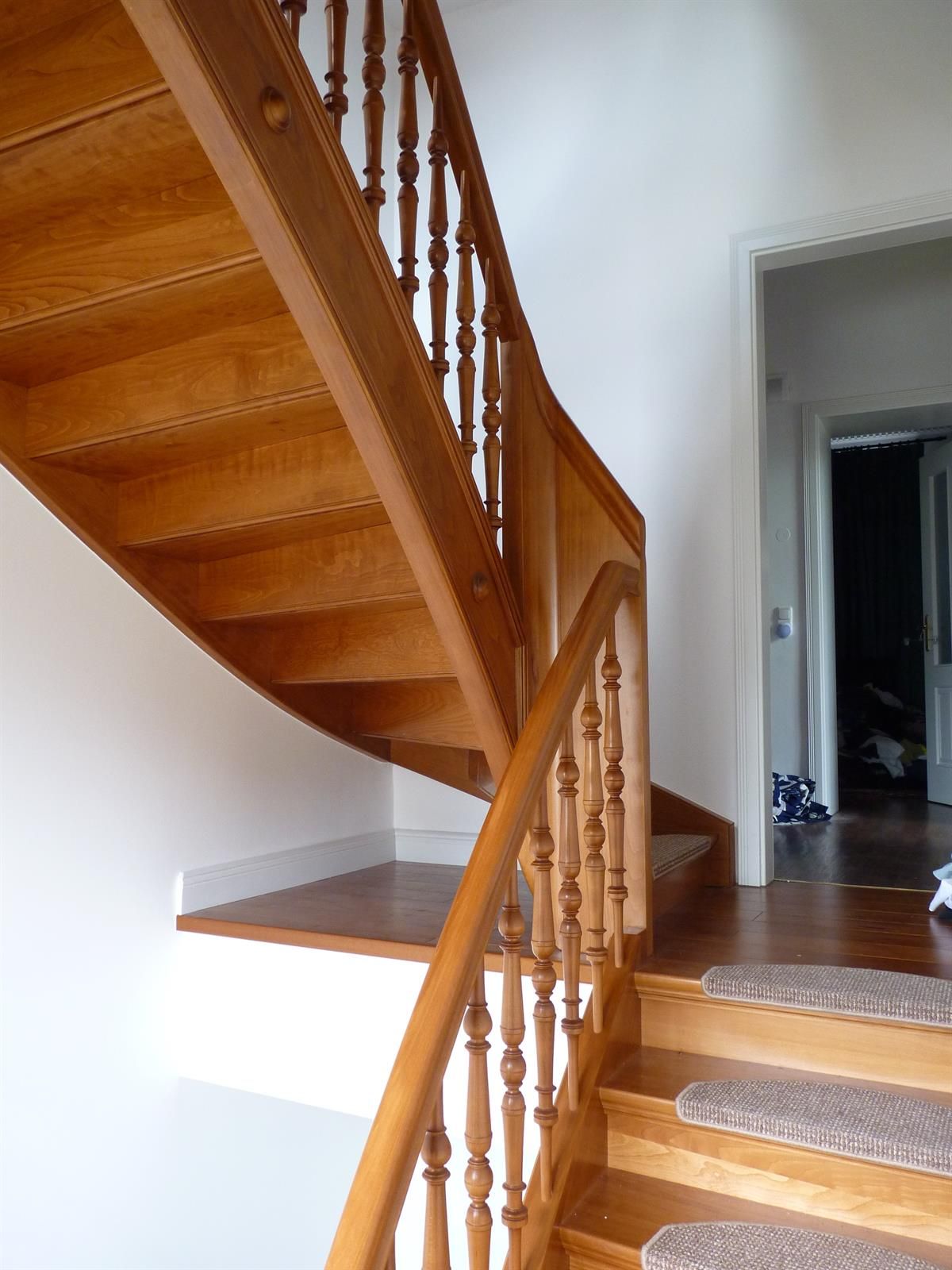 Eine hölzerne Wendeltreppe mit einem weißen Geländer