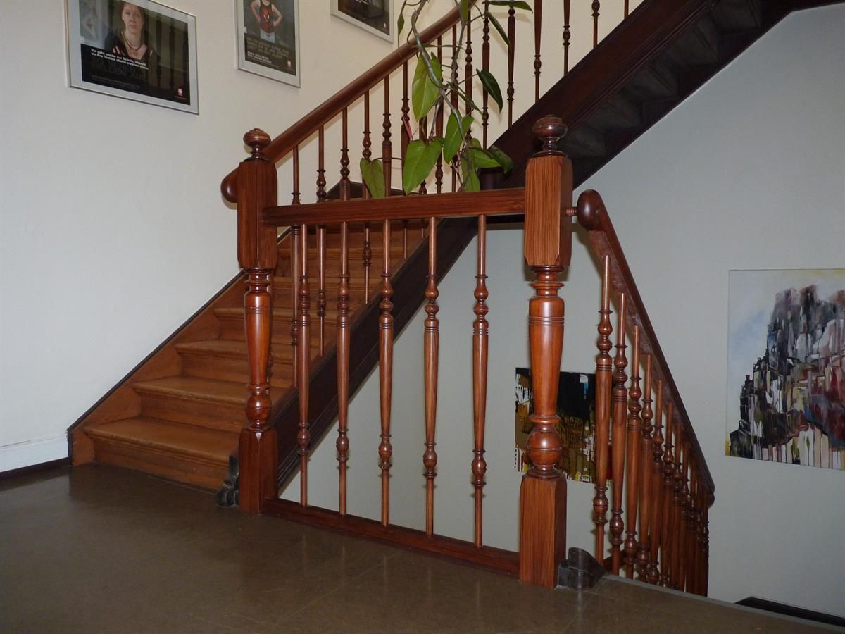 Eine Holztreppe mit einem Gemälde an der Wand dahinter