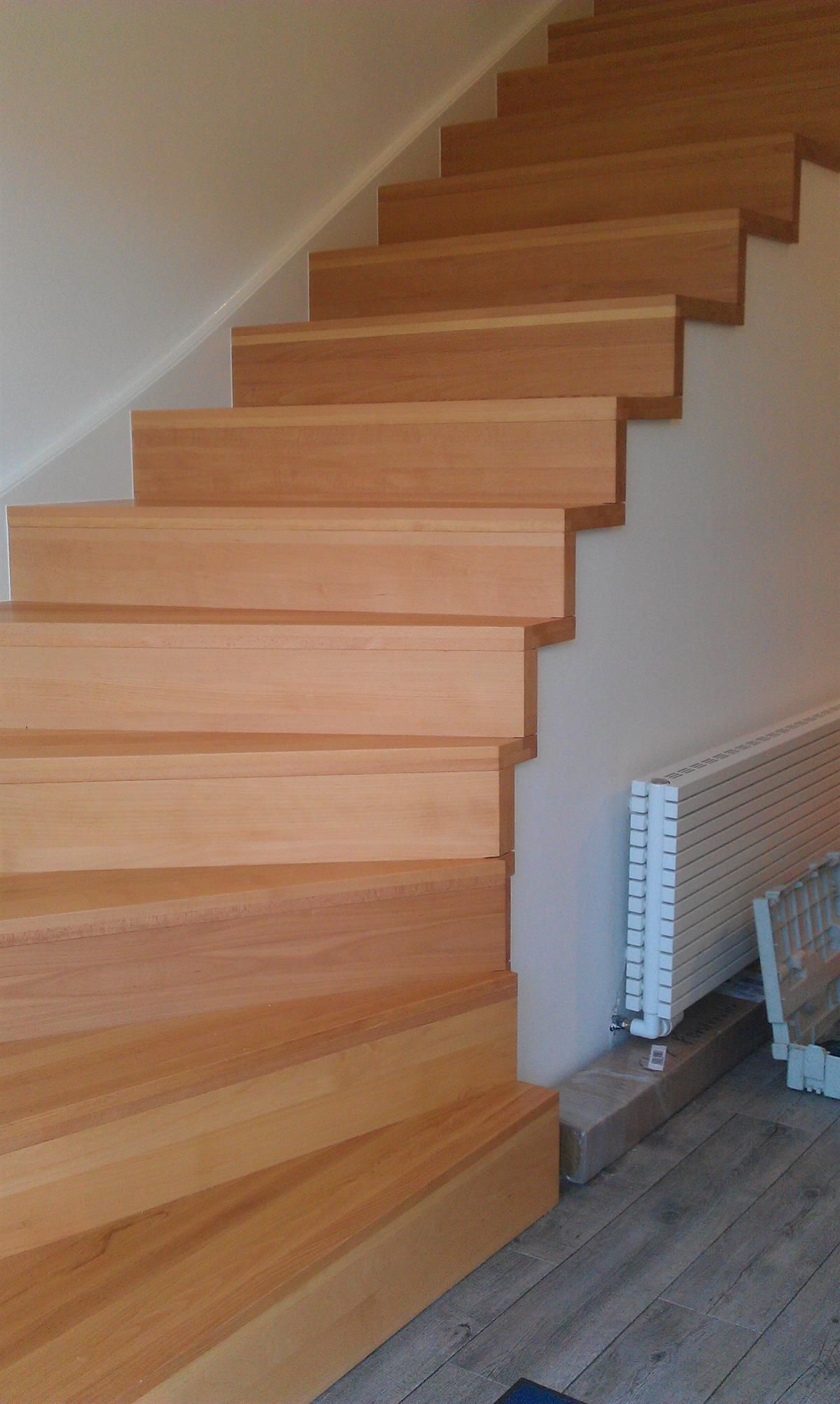 Eine Holztreppe mit einer weißen Wand dahinter