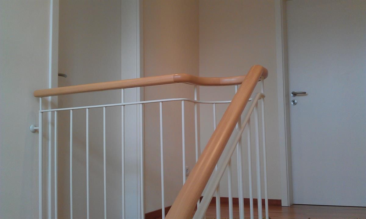 Eine Treppe mit einem weißen Geländer und einem Holzhandlauf