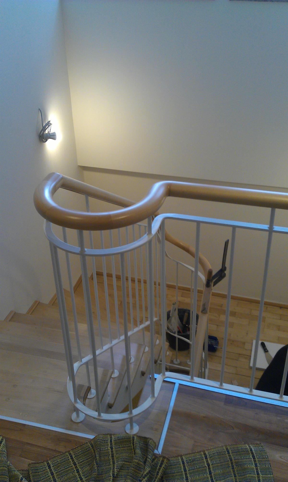 Eine Wendeltreppe mit weißem Geländer und Holzhandläufen