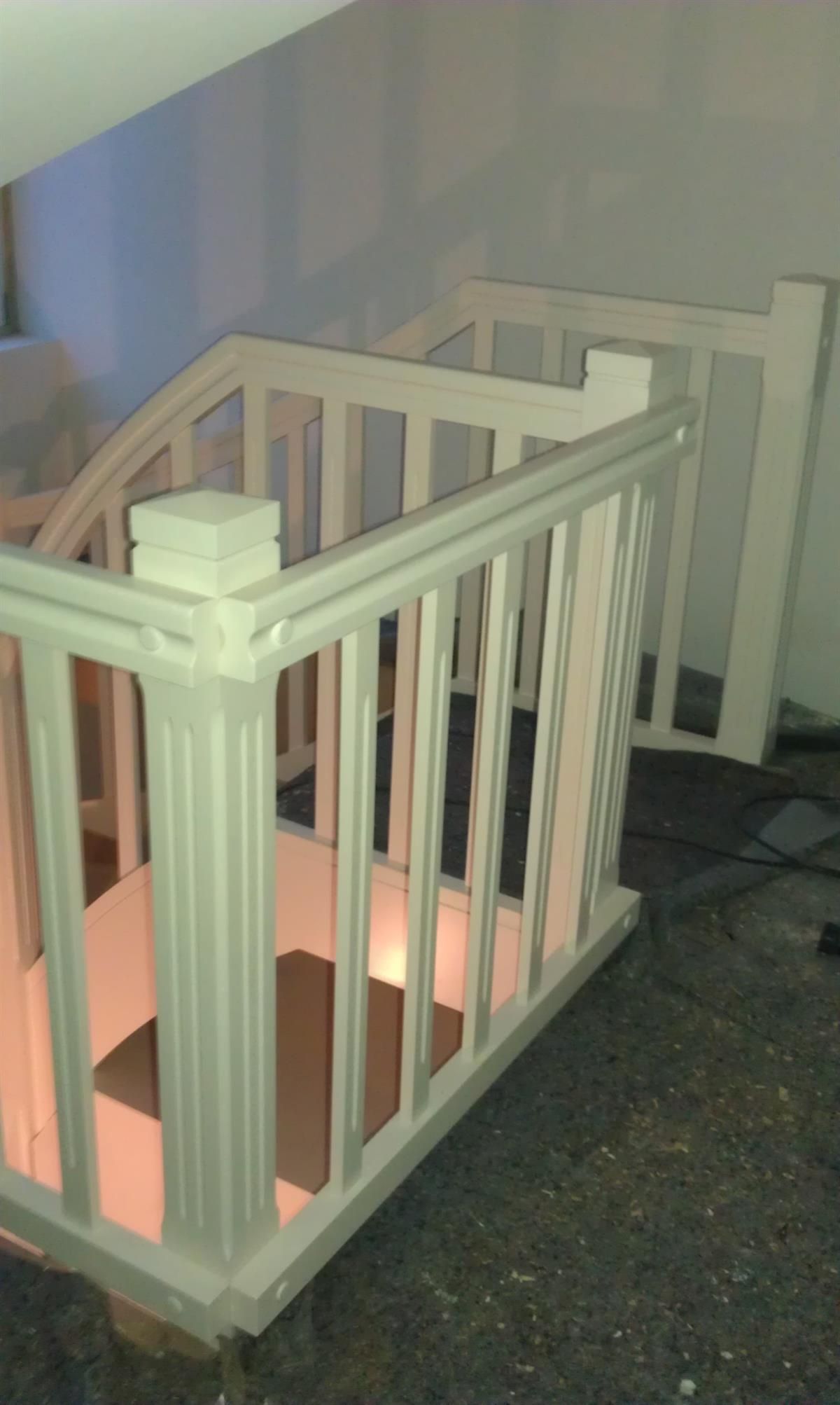 Ein weißes Geländer auf einer Wendeltreppe in einem Haus