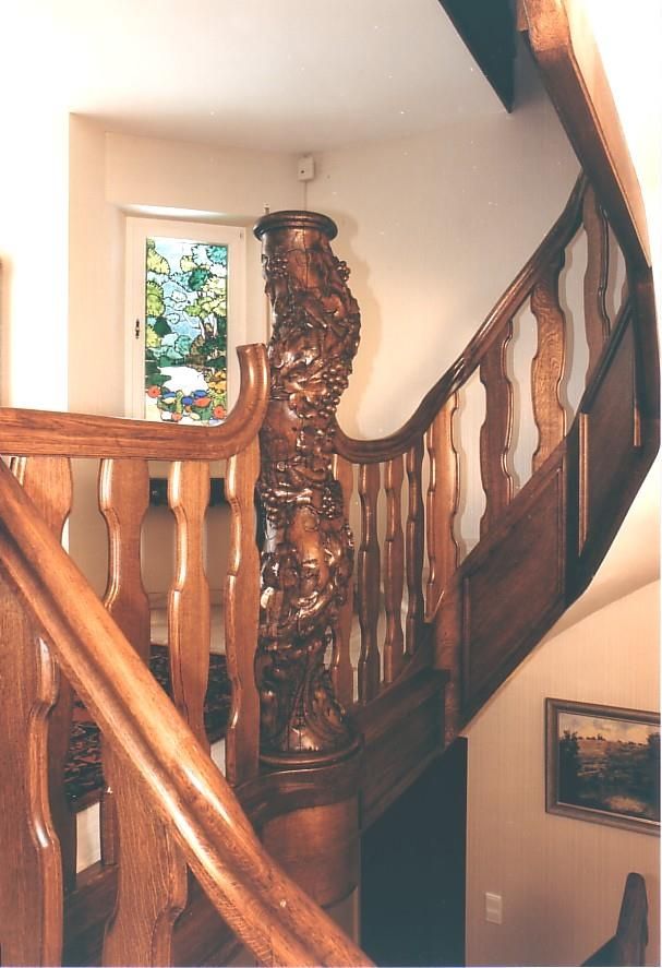 Eine Holztreppe mit einem Buntglasfenster im Hintergrund