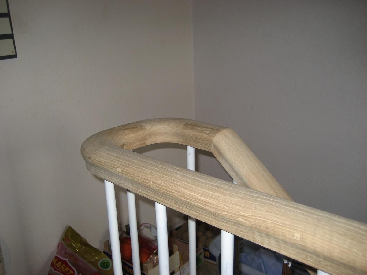 Eine Treppe mit einem weißen Geländer und einem Holzhandlauf