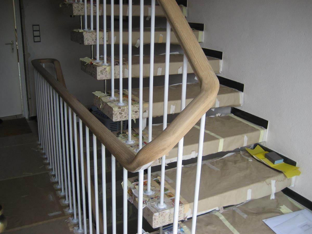 Eine Treppe mit einem weißen Geländer und einem Holzhandlauf