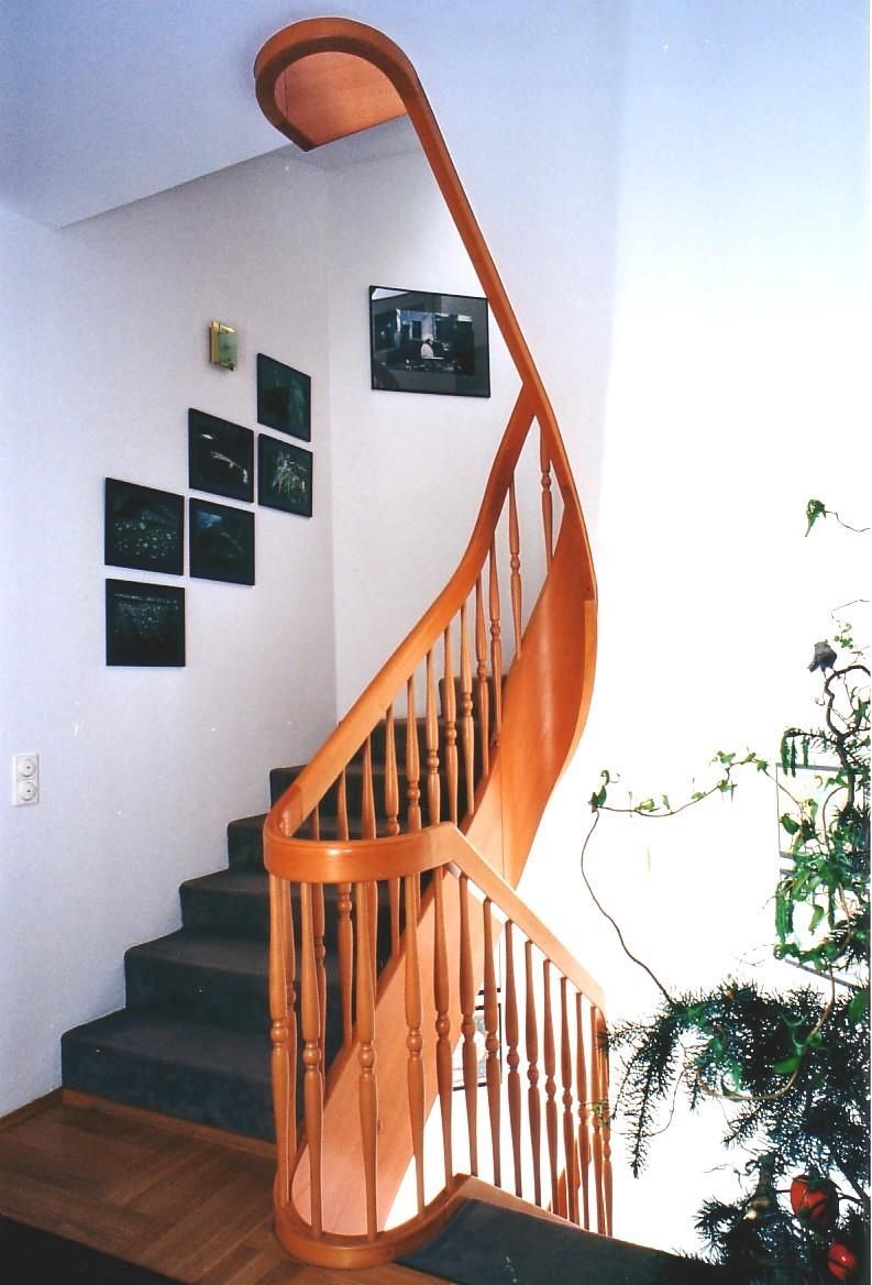 Eine hölzerne Wendeltreppe mit einem Weihnachtsbaum im Hintergrund