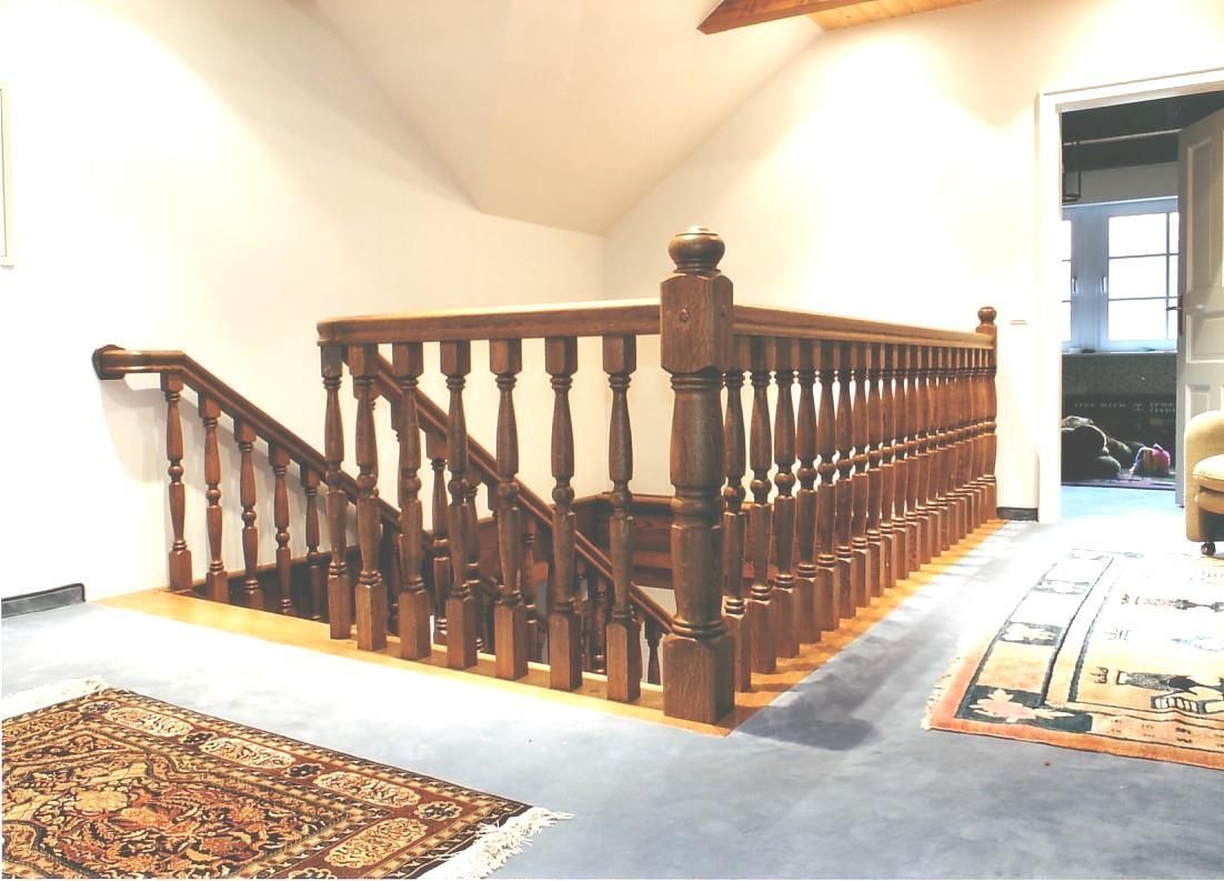 Eine Holztreppe in einem Raum mit einem Teppich auf dem Boden