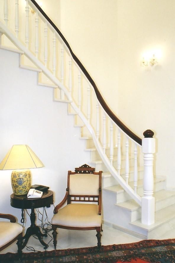 Eine Lampe steht auf einem Tisch neben einem Stuhl und einer Treppe