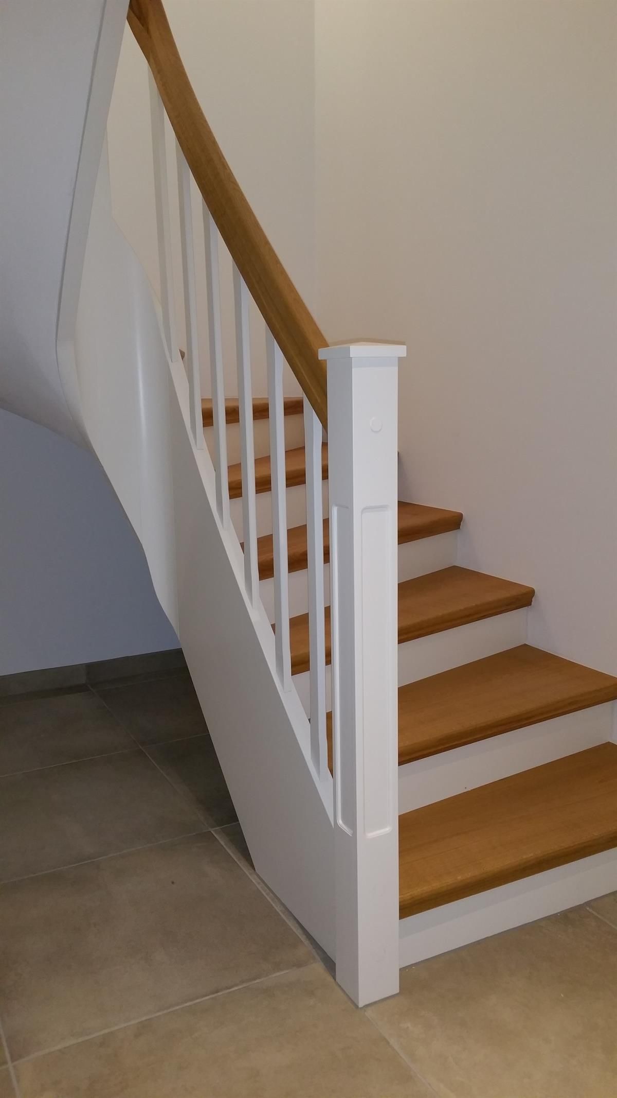 Eine Treppe mit Holzstufen und einem weißen Geländer