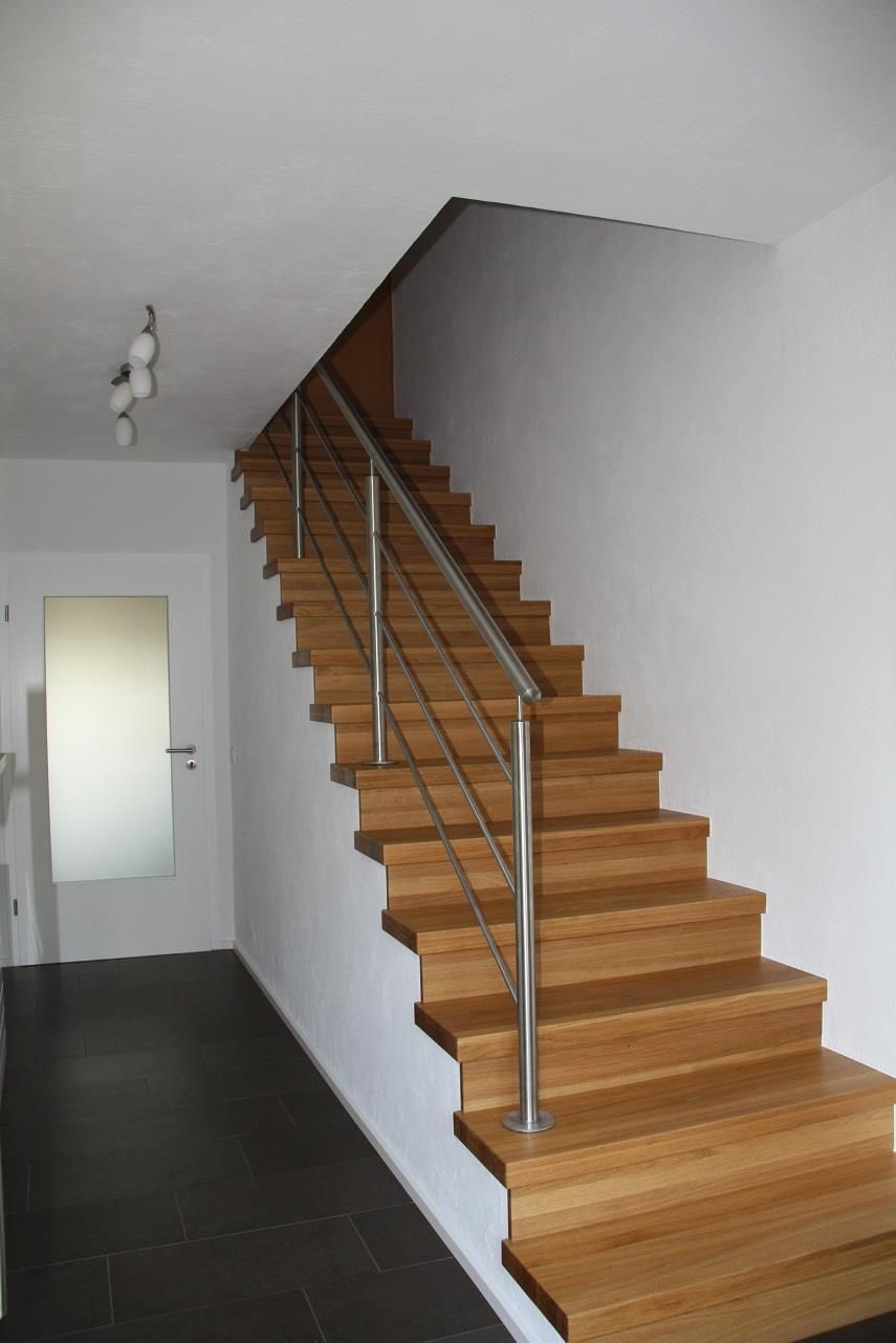 Eine Holztreppe mit einem Metallgeländer in einem Flur