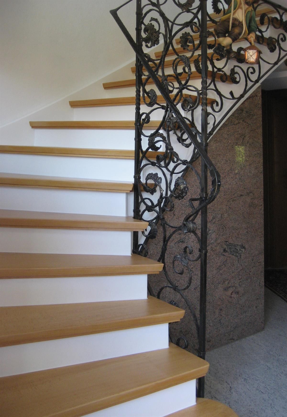 Eine Treppe mit Holzstufen und einem schmiedeeisernen Geländer