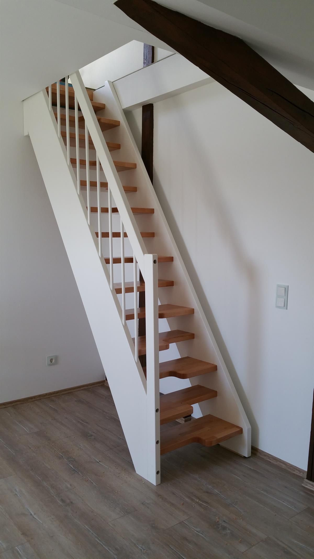 Eine weiße Treppe mit Holzstufen in einem Zimmer