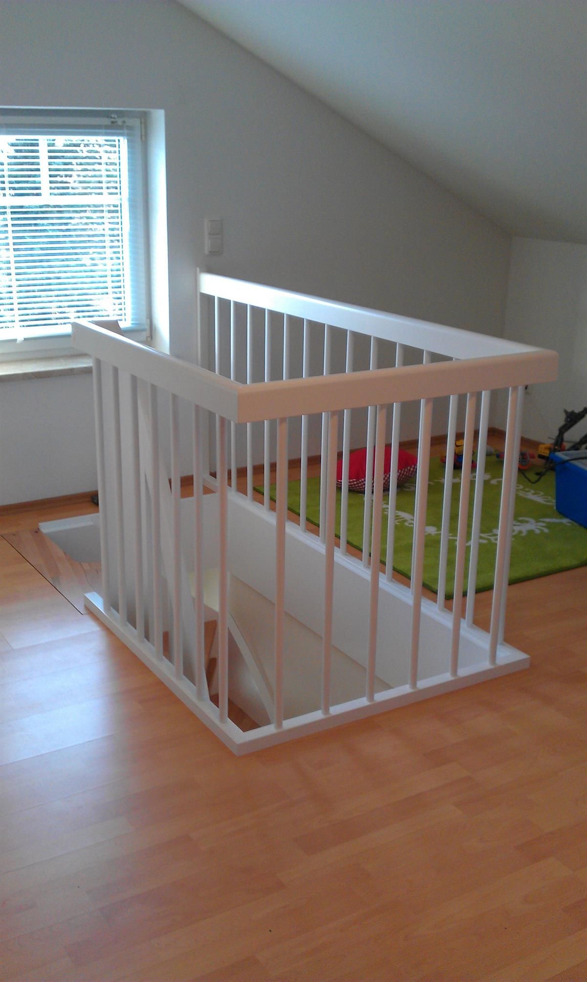 Eine Holztreppe mit einem weißen Geländer in einem Zimmer