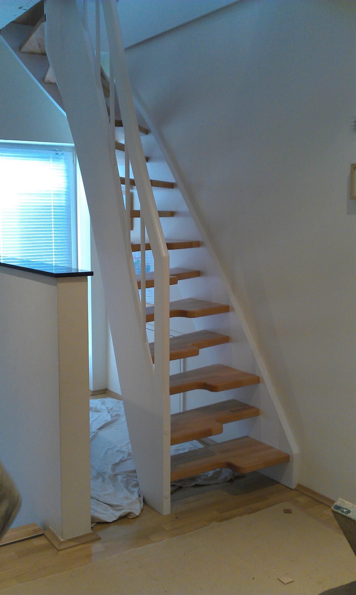 Eine weiße Treppe mit Holzstufen in einem Zimmer