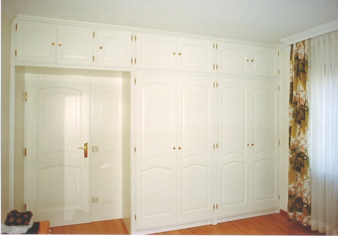 Ein Raum mit vielen weißen Schränken und einer Tür