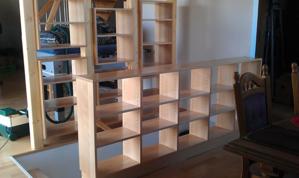 Eine Reihe von Holzregalen in einem Raum mit einem Tisch und Stühlen