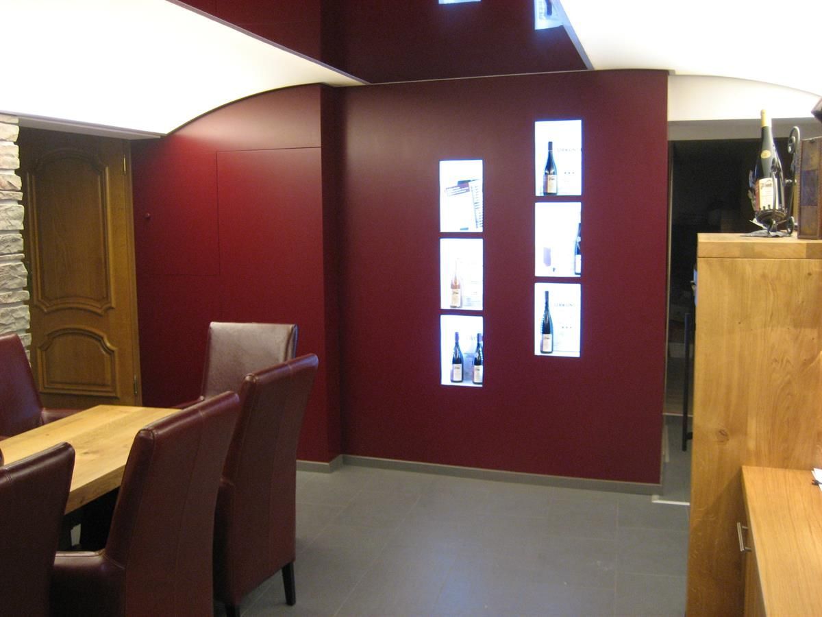 Ein Esszimmer mit roten Wänden und einem Tisch und Stühlen