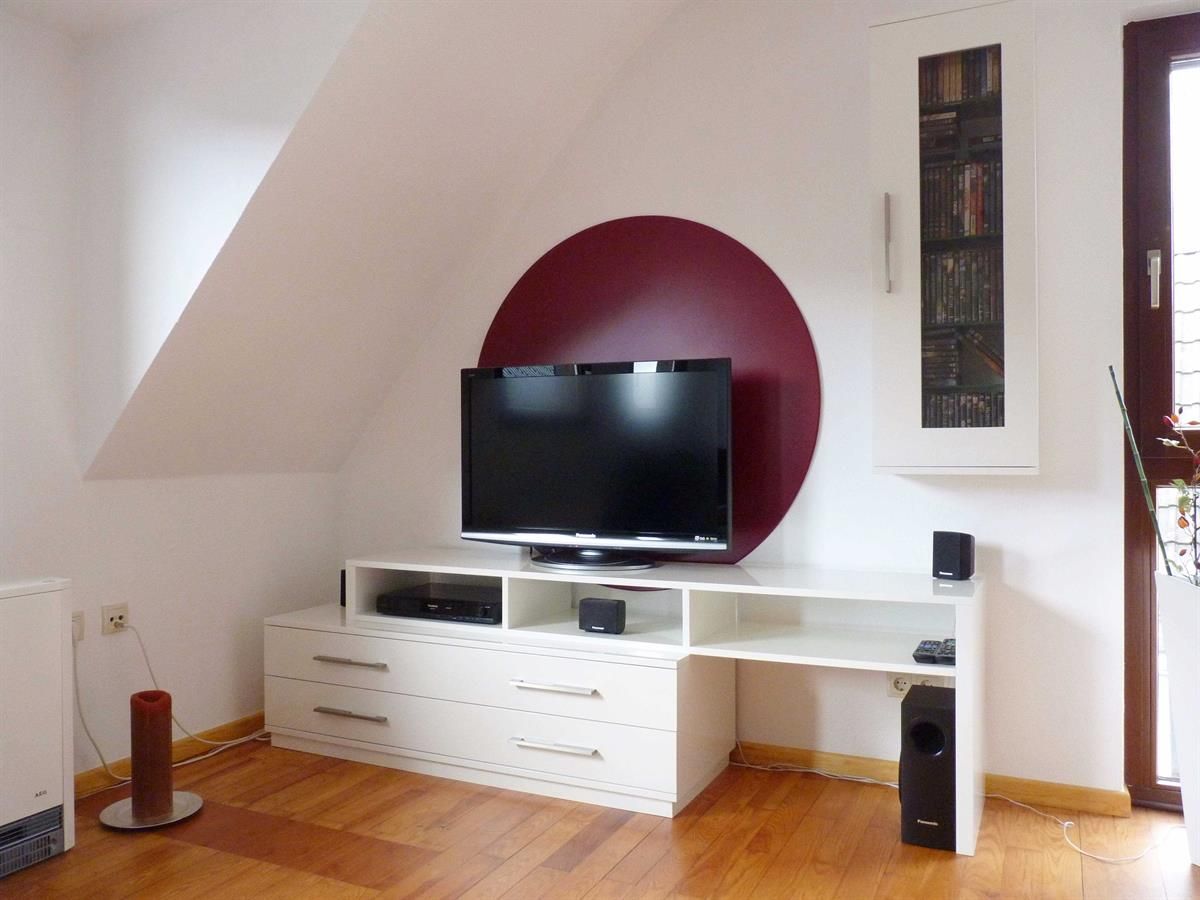 Ein Wohnzimmer mit einem Flachbildfernseher auf einem Ständer