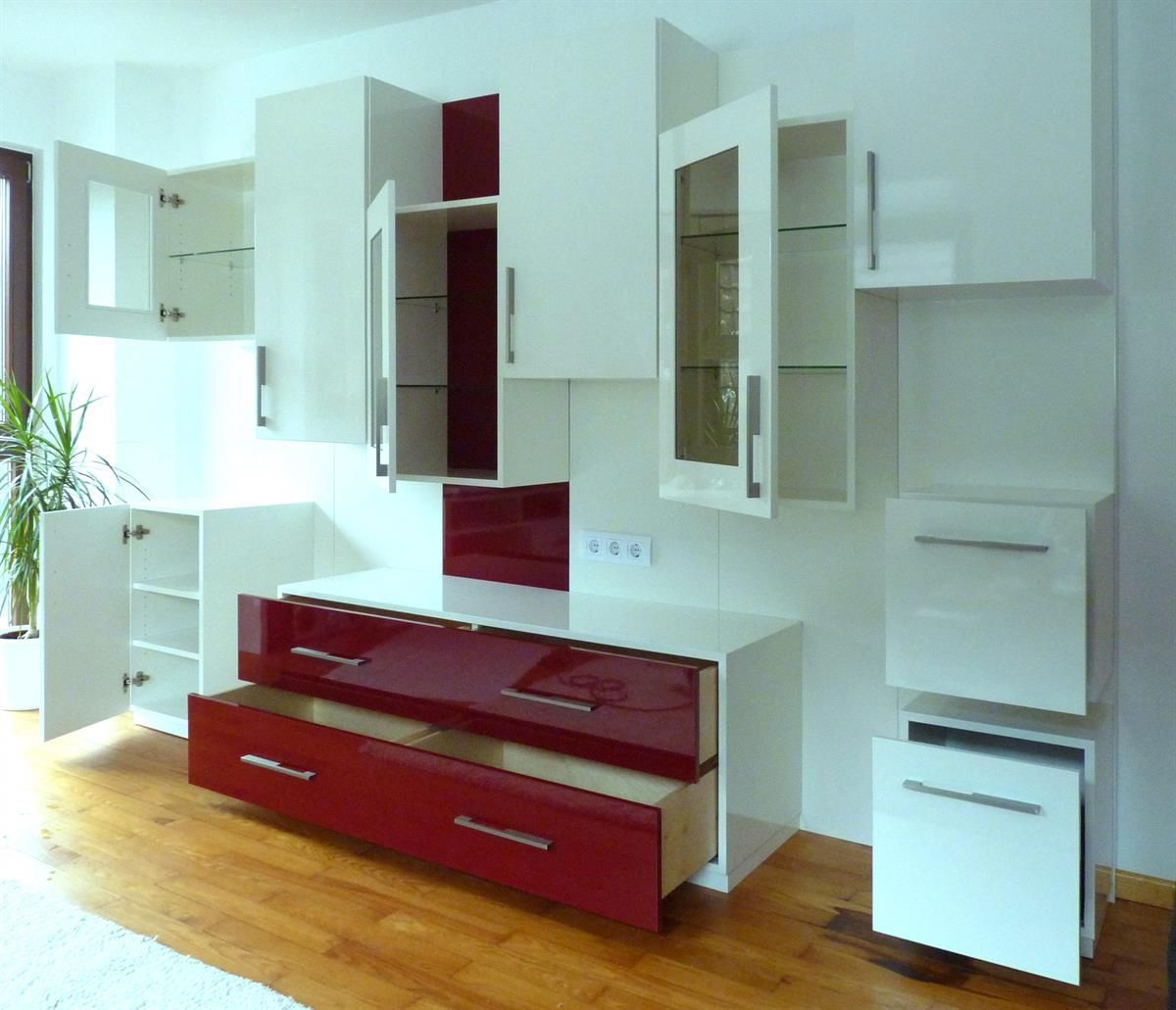 Ein Wohnzimmer mit weißen Schränken und roten Schubladen