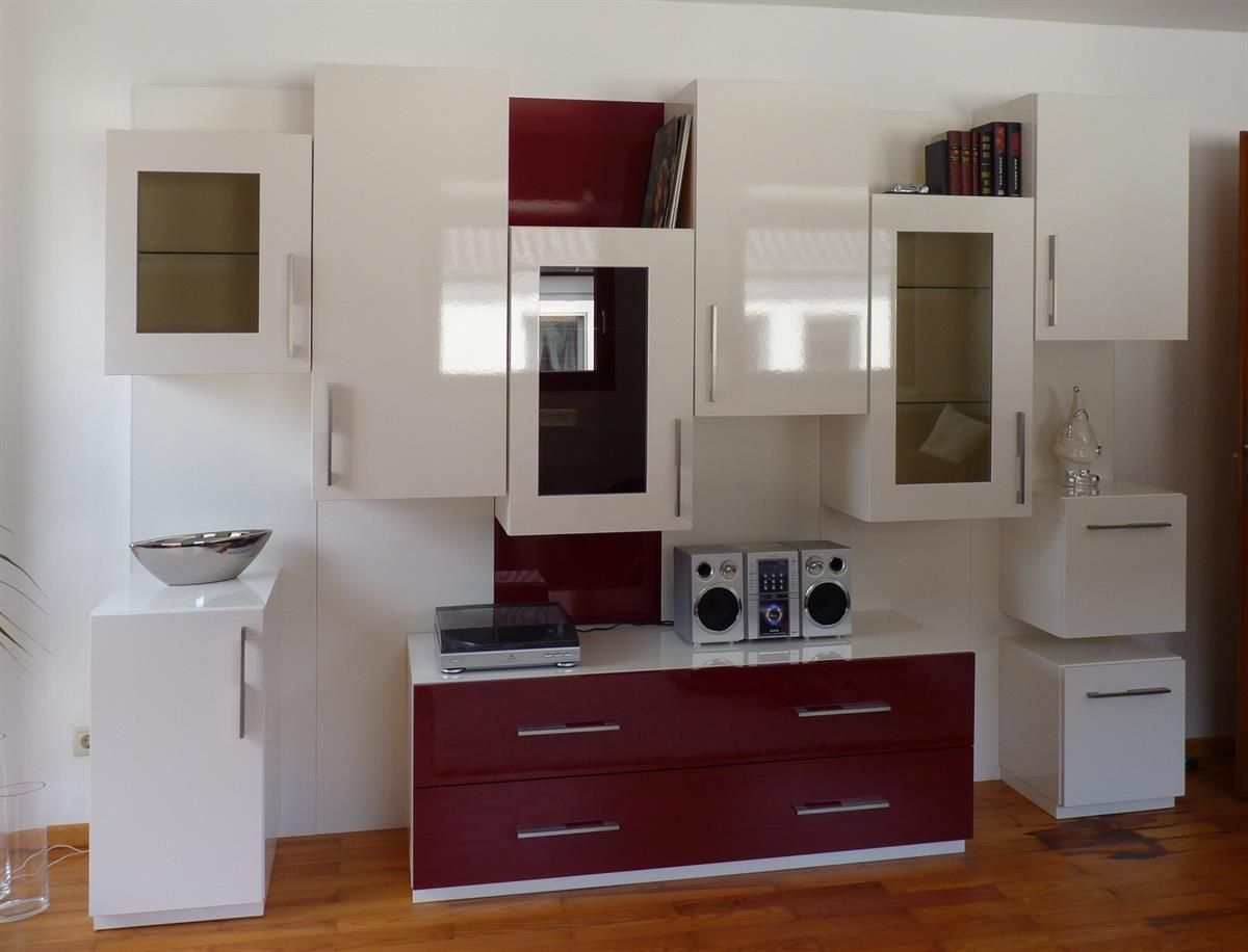 Ein Wohnzimmer mit weißen Schränken und roten Schubladen