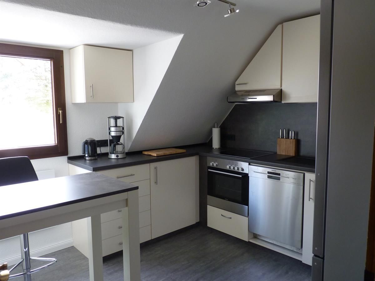 Eine Küche mit weißen Schränken und Geräten aus Edelstahl