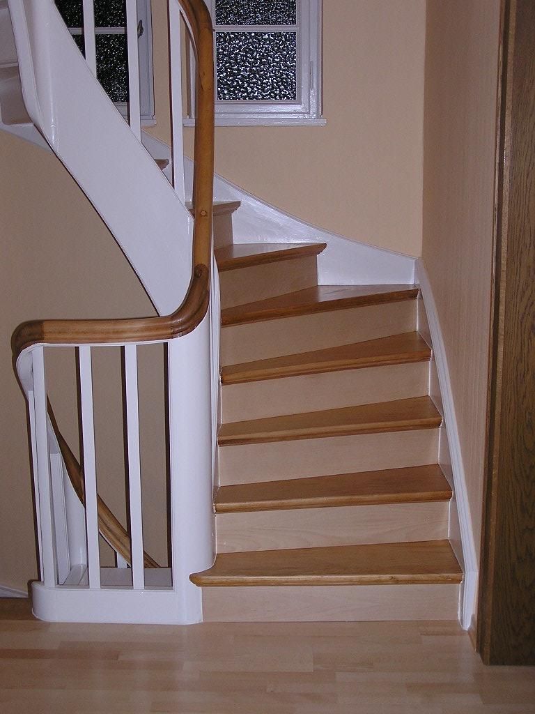 Eine Treppe mit Holzstufen und einem weißen Geländer