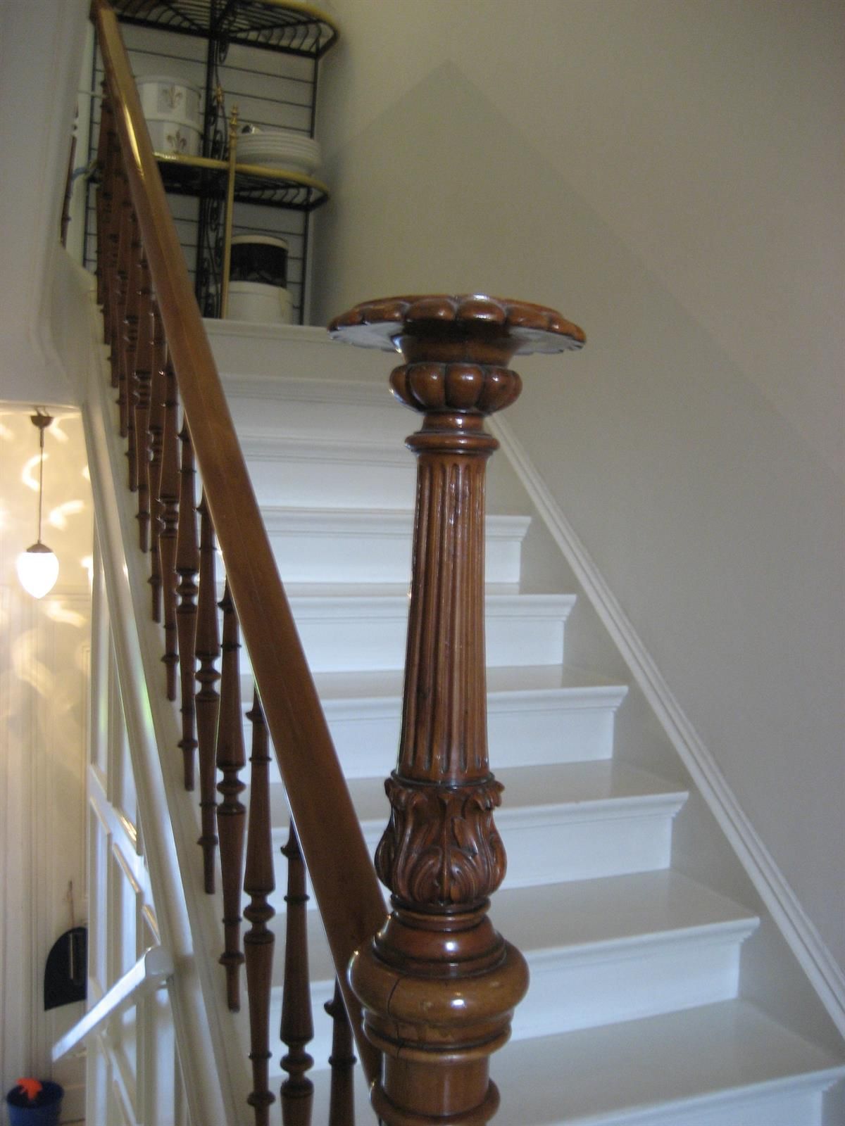 Ein Holzgeländer auf einer weißen Treppe