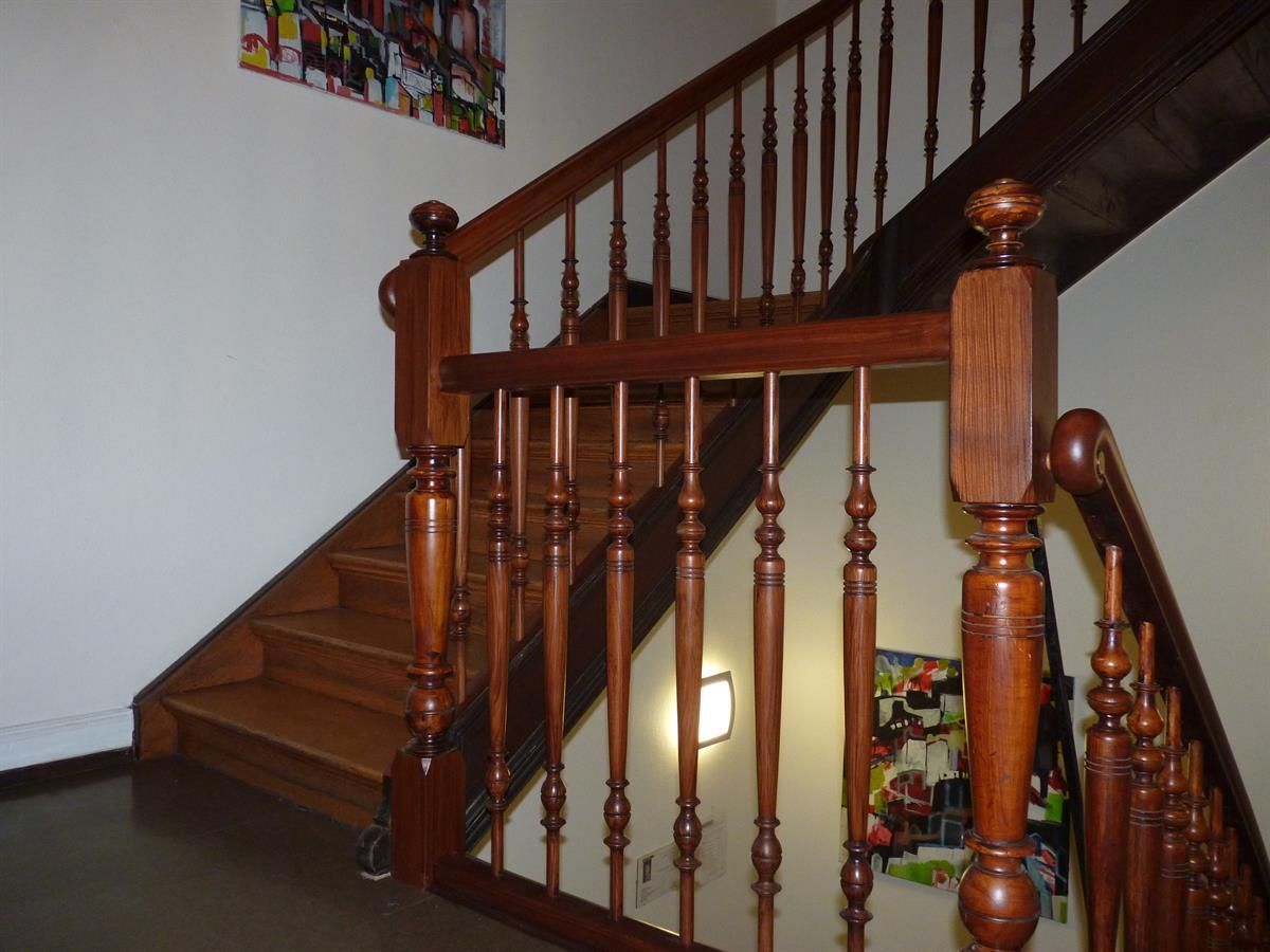 Eine Holztreppe mit einem Gemälde an der Wand darüber