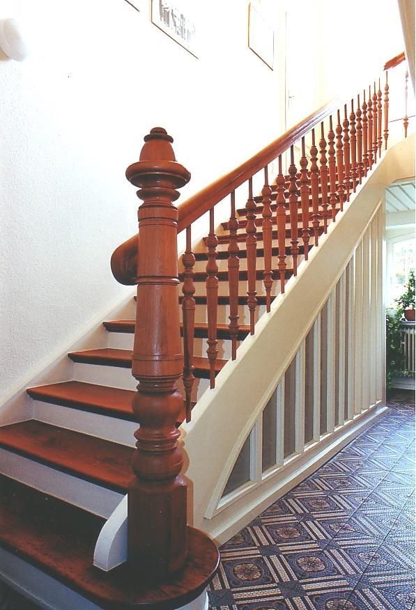 Eine Holztreppe mit weißen Stufen und einem Holzgeländer