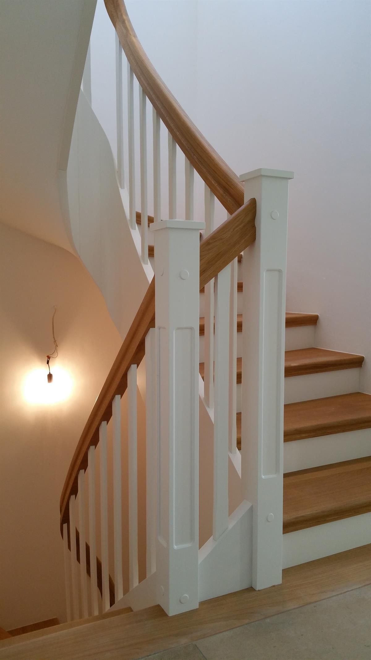 Eine Treppe mit weißem Geländer und Holzstufen