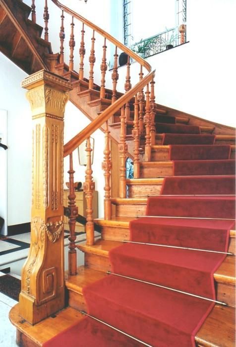 Eine Holztreppe mit einem roten Teppich auf den Stufen