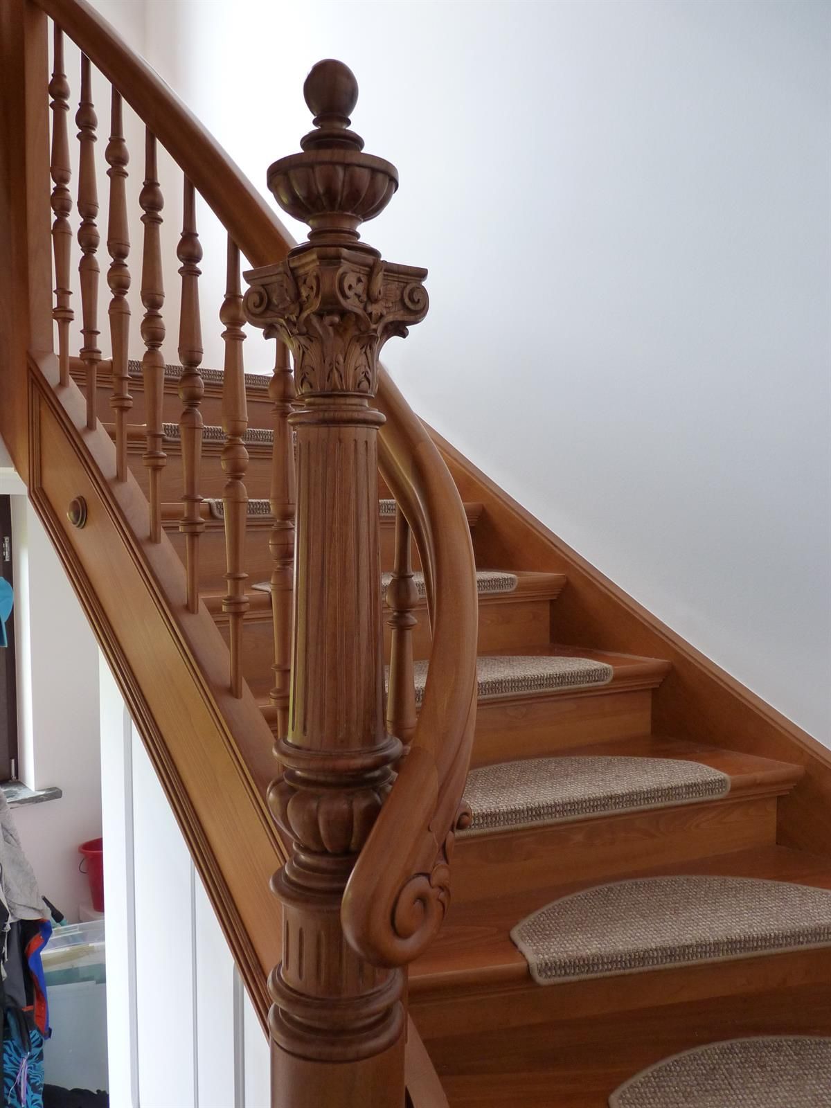 Eine Holztreppe mit einem ausgefallenen Holzgeländer