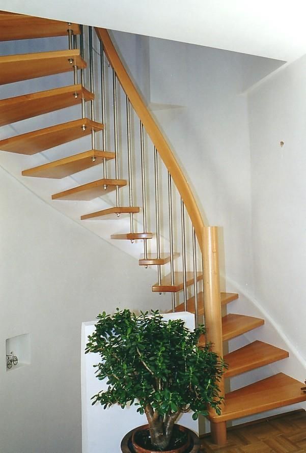 Eine Holztreppe mit einer Topfpflanze in der Ecke