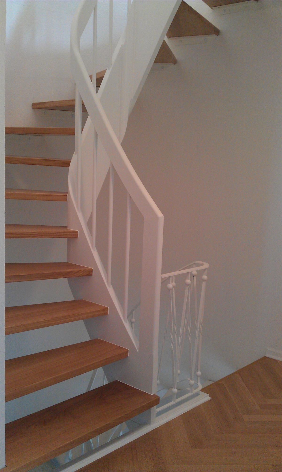 Eine Treppe mit Holzstufen und einem weißen Geländer
