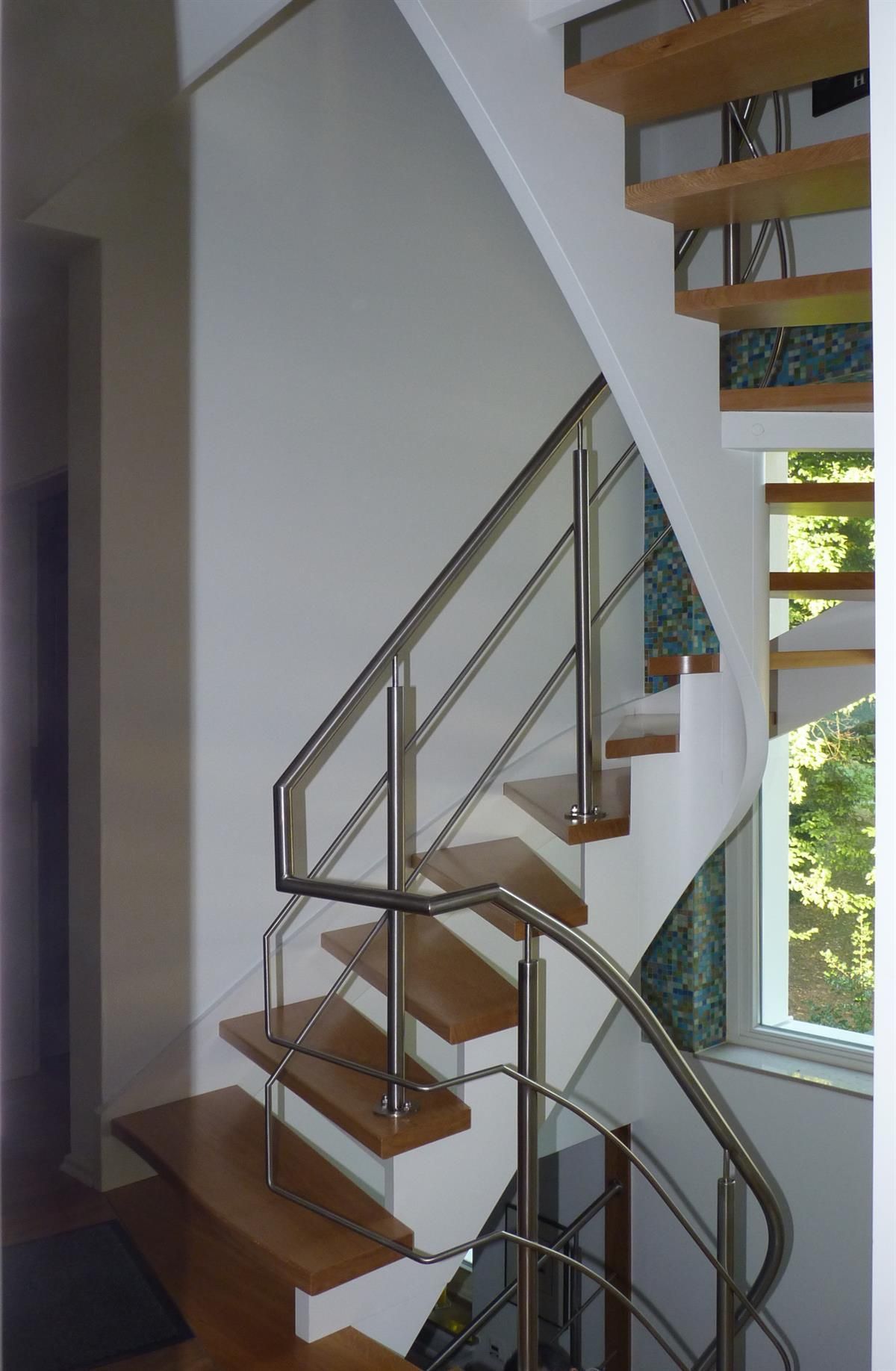 Eine Wendeltreppe mit Holzstufen und Edelstahlgeländer