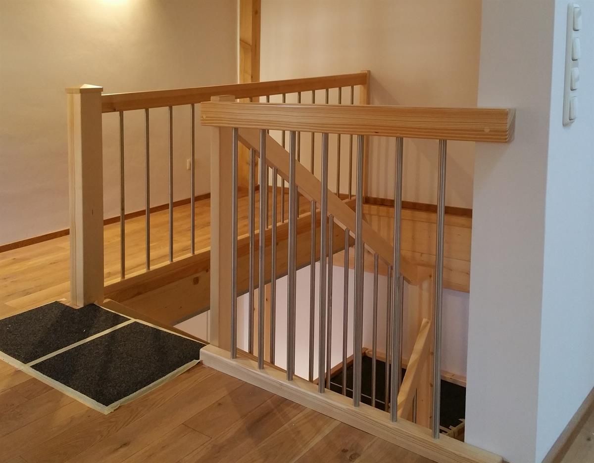 Eine Treppe mit einem Holzgeländer und einem Metallgeländer
