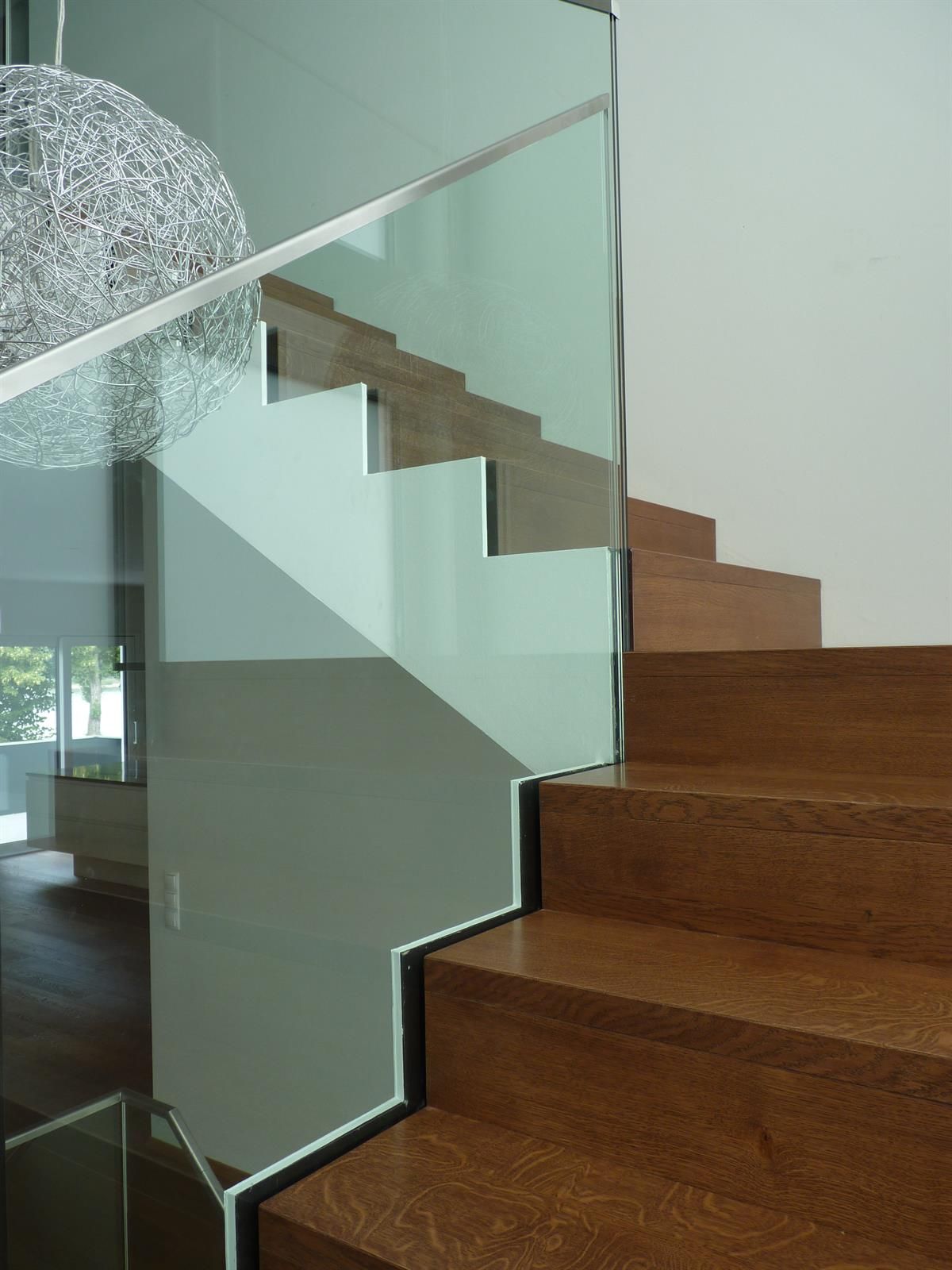 Eine Holztreppe mit klarem Glasgeländer