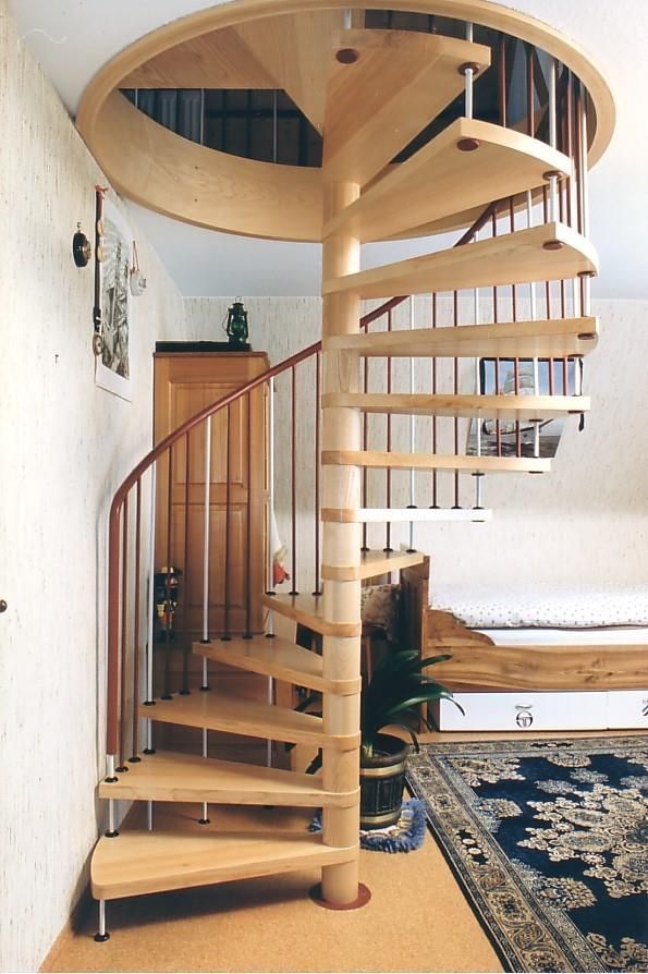 Eine hölzerne Wendeltreppe in einem Raum mit einem Teppich