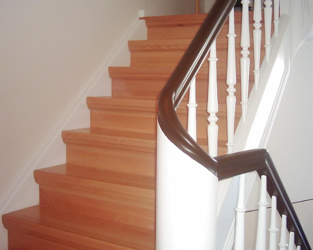 Eine Treppe mit Holzstufen und weißem Geländer