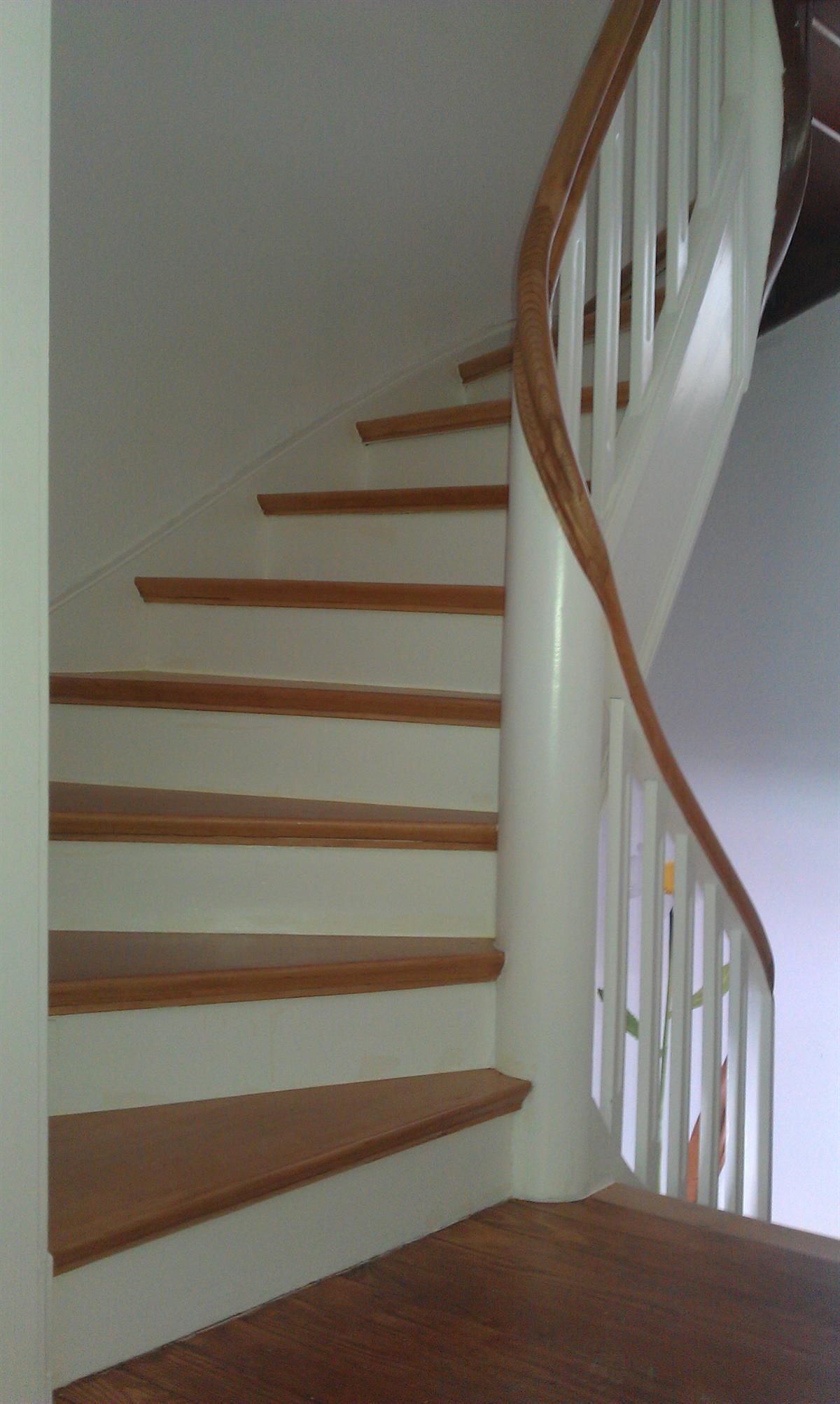 Eine Treppe mit Holzstufen und einem weißen Geländer