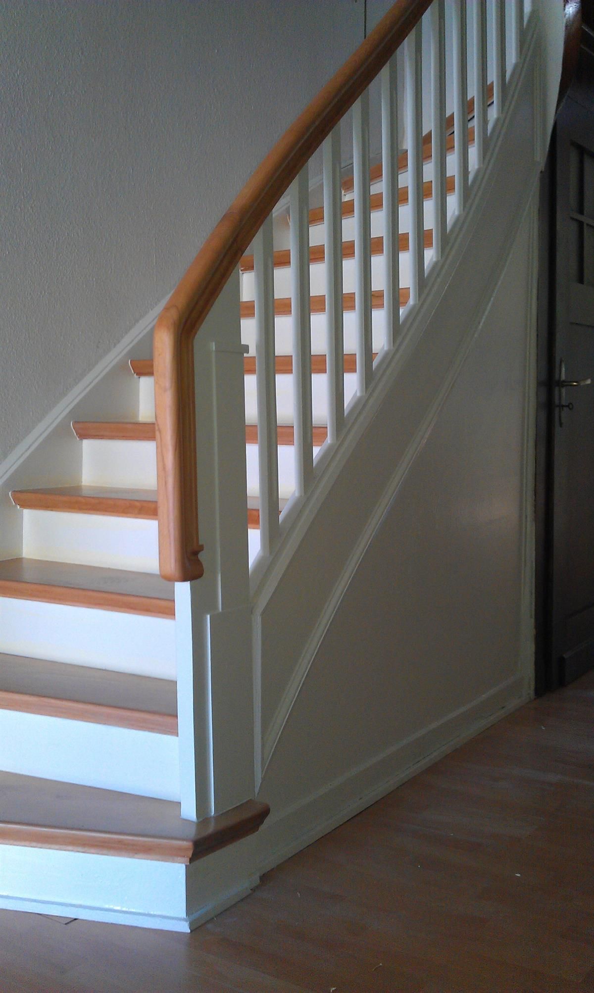 Eine weiße Treppe mit Holzstufen und einem Holzgeländer